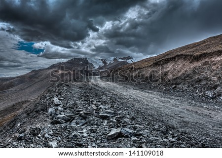 Road in Himalayas near Tanglang la Pass  - Himalayan mountain pass on the Leh-Manali highway in stormy weather. Ladakh, India Royalty-Free Stock Photo #141109018
