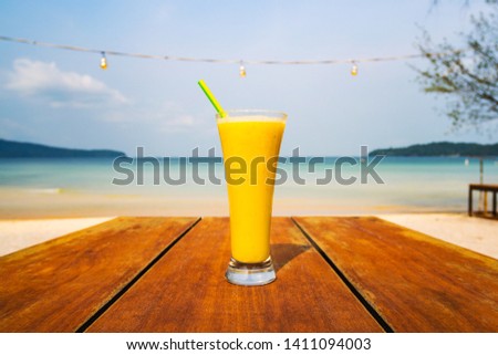 yellowcocktail on table, sea background. Vacation, vacation summer pleasure concept. Delicious fruit shake on the background of a deserted beach on a tropical island in Asia.