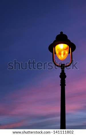 lamppost illuminated at twilight with beautiful sky