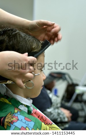 Small child sitting at the hairdresser's