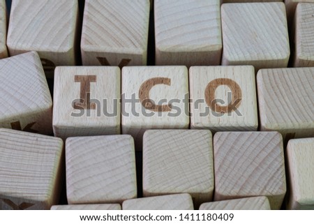 ICO, initial coin offering for crypto currency industry concept, cube wooden block with alphabet combine the word ICO on black chalkboard background.