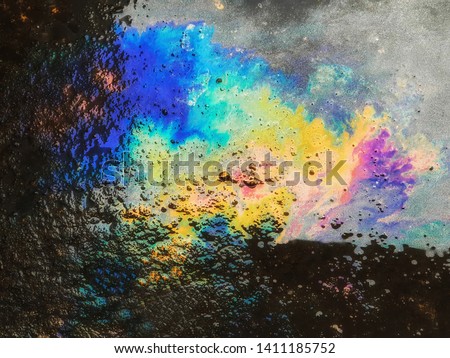 Pattern of Oily Rainbow stains on the cement. road.abstract background. Image caused by inattention.