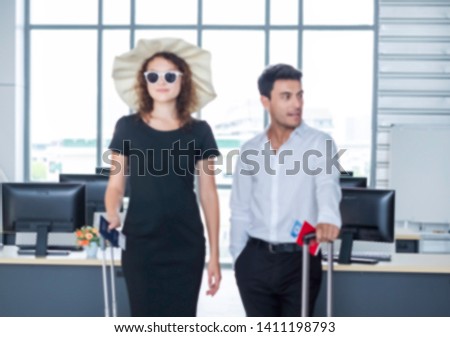 Blurred background of businessmen ready for summer vacation. The officers wear business attire in workplace but holding passport & suitcase. They traveling abroad as globe trotters. Getaway concept. 