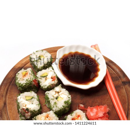 Japanese food. Sushi and sauce on a wooden board on a white background          