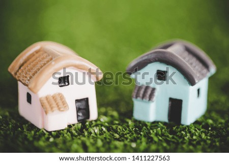Miniature house on artificial grass floor there is copy space. Home, Housing and Real Estate concept