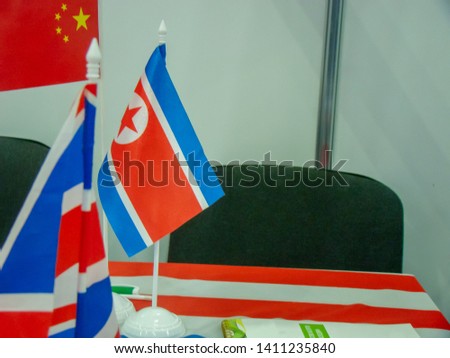 The venue is North Korea (DPRK). Flags of the Republic. In the background is the flag of China (PRC). Table, chair. The concept of negotiations with the United States. "deliberately blurred"
