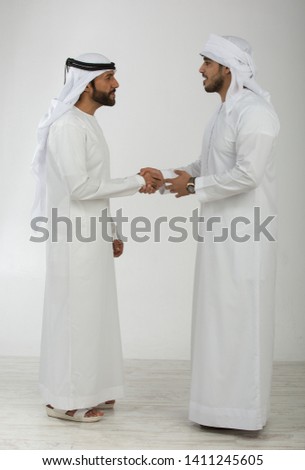 Two emirati men on plain background Royalty-Free Stock Photo #1411245605