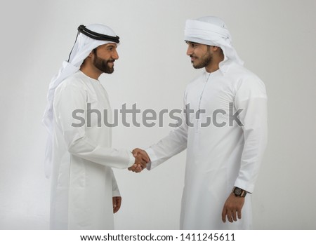 Two emirati men on plain background Royalty-Free Stock Photo #1411245611