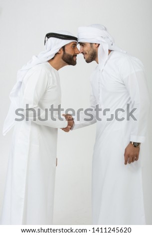 Two emirati men on plain background Royalty-Free Stock Photo #1411245620