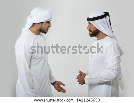 Two emirati men on plain background Royalty-Free Stock Photo #1411245653