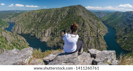 Woman taking pictures in a beautiful viewpoint in the Sil Canyon. Ribeira Sacra, Galicia