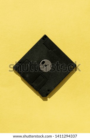 black floppy disk on yellow background. retro magnetic storage