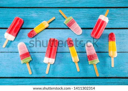 Colorful fruit ice cream stick look fresh to eat placed on a blue vintage wooden.