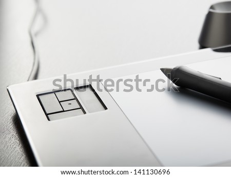Graphic tablet with pen on table Royalty-Free Stock Photo #141130696