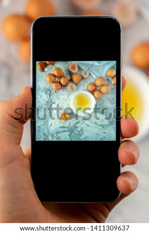 top view of hand holding a phone doing a mobile food photography