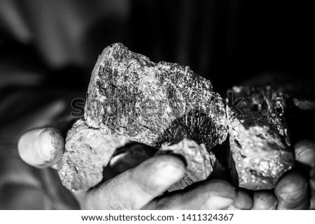 Coal mining : coal miner in the man hands of coal background. Picture idea about coal mining or energy source, environment protection. Industrial coals holding on hands. Volcanic rock. 