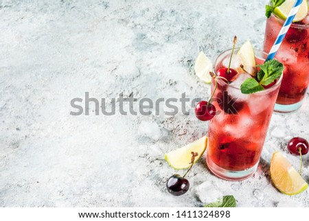 Summer iced refreshment drink, cherry cola lemonade or mojito cocktail in tall glass, on light blue and grey background copy space top view