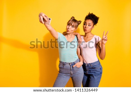 Portrait funky charming two people student make photo v-sign summer travel lips pouted plump wavy hairstyle bun top-knot trendy stylish style jeans t-shirt isolated yellow background childish carefree