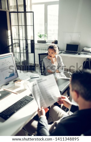 Uncomfortable interview. Dark-haired young woman feeling uncomfortable during job interview Royalty-Free Stock Photo #1411348895