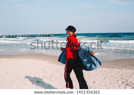 Freedom woman in free happiness bliss on beach. Smiling happy multicultural female model in jeans coat enjoying serene ocean nature during travel holidays vacation outdoors, running on the beach.