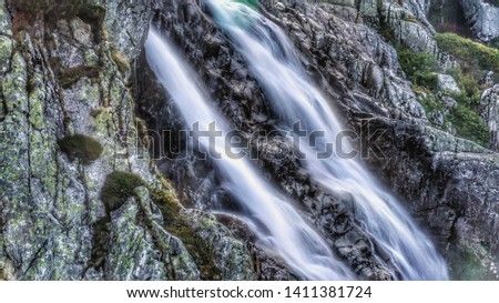 Siklawa Waterfall close to the Five Polish Lakes Valley in Tatra mountains range in Tatra National Park. Long exposure photo. Smokey water.