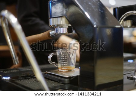 Close-up of espresso shot pouring from coffee machine. Professional coffee brewing