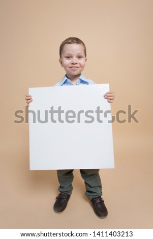 a child with a white sign is smiling