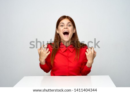 Emotional woman in red shirt desktop internet work studio expression official