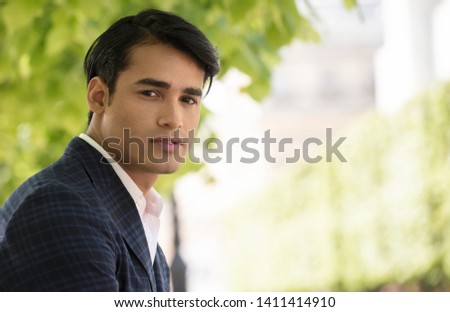 Street fashion concept. Portrait of elegant young handsome man. Parisian buildings as background.