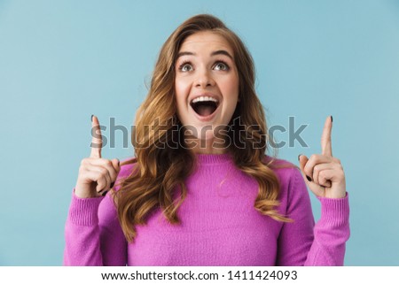 Beautiful young girl wearing casual clothes standing isolated over blue background, presenting copy space