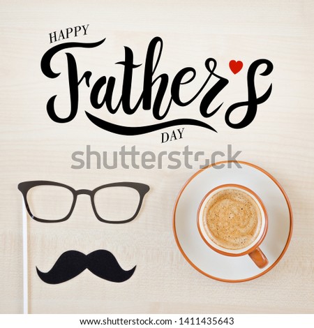 Mustache, glasses and cup of coffee on wooden background. Happy Father's day background. Hand sketched Happy Fathers Day lettering typography. Copy space for inscription. Greeting card