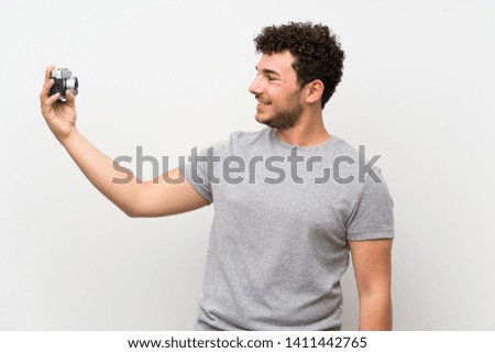 Man with curly hair over isolated wall making a selfie