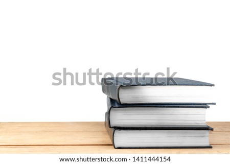 Pile of books on wooden table isolated over white background. Back to School concept