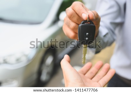 Businessman giving a car key. Getting new car concept. Royalty-Free Stock Photo #1411477706
