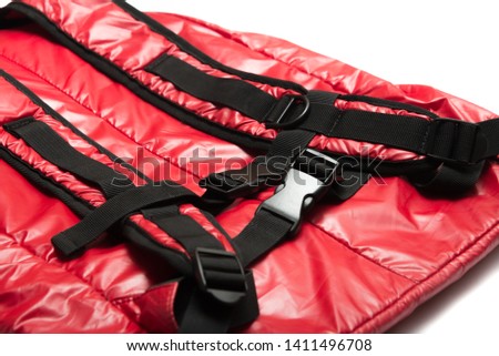 Red shiny nylon backpack isolated on white background.
