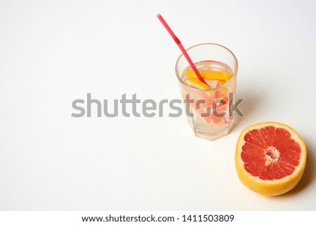 Grapefruit lemonade in a glass. Cold summer lemonade with ice cubes. Alcoholic cocktails