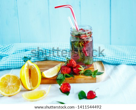Two fresh glasses of lemon lemonade and strawberry on a blue background and fruit