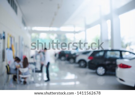 Blurred dealership store, with the cars and soft lightning., new car pictures in the showroom,  show waiting for sales of branch dealers and new car service centers.