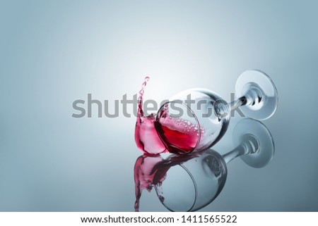 Red wine spilled out of a falling glass reflected on the surface