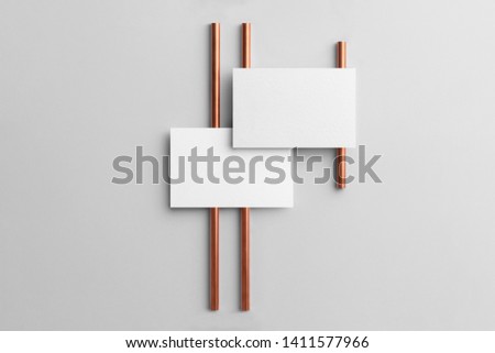 Real photo, business cards branding mockup template to place your design, isolated on light grey background, with copper tubes.