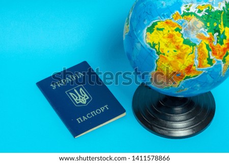 Passport of a citizen of Ukraine near the globe on a blue background