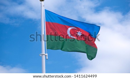 flag of the Republic of Azerbaijan waving in sunny blue sky.