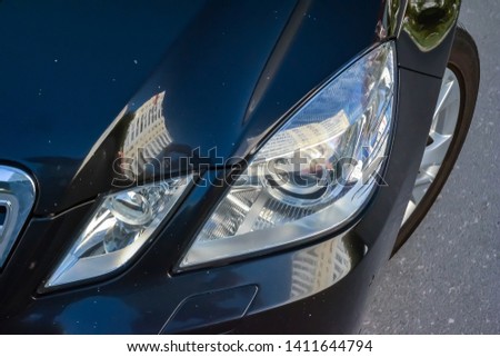Close-up on the hood and fender of the car in black with white dots in the form of chips from stones and rubble that fly off the road. Repair scratches and defects in the body repair workshop. Royalty-Free Stock Photo #1411644794