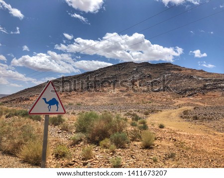 Camel crossing road sign. Warning sign  for dromedaries. Highway in Morocco. Wild camels crossing - Image