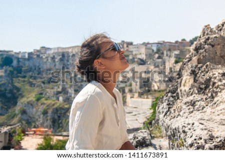 Young elegant woman tourist in historical Matera town in Italy looking at cityscape