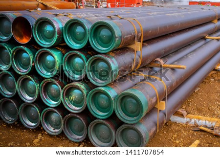 Stacked steel pipe with sunlight  reflecting on the interior walls. Stack of new metal pipes. Industrial material.