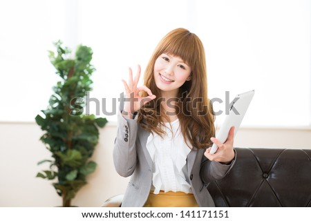 Beautiful young asian businesswoman using tablet computer