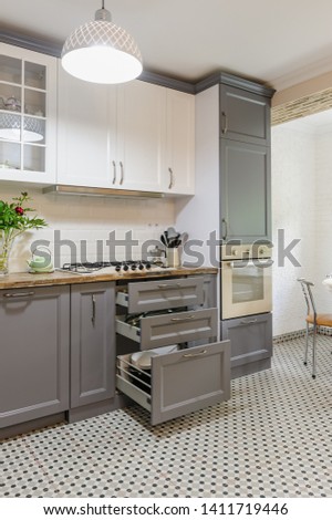 interior of modern luxury grey and white wooden kitchen, some drawers are open