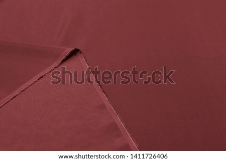 Abstract background texture of natural red color fabric. Fabric texture of natural cotton or linen, silk or satin, wool or jersey textile material. Luxurious red canvas background.
 Royalty-Free Stock Photo #1411726406