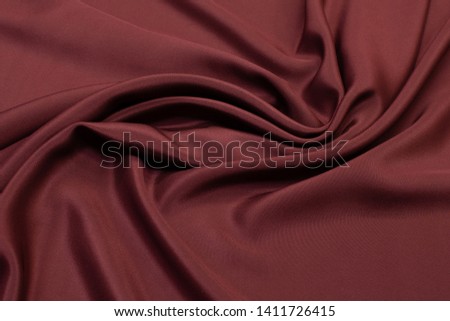 Abstract background texture of natural red color fabric. Fabric texture of natural cotton or linen, silk or satin, wool or jersey textile material. Luxurious red canvas background.
 Royalty-Free Stock Photo #1411726415